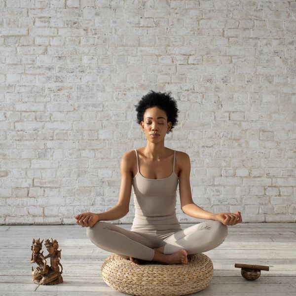 Serene woman meditating, symbolizing the mental clarity and energy from regular practice.